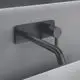 Wandarmatur in mattem Schwarz, montiert an einer Wand, von Ideal Standard. Der Wasserhahn hat eine eckige Rosette und eine schlichte, geradlinige Form.